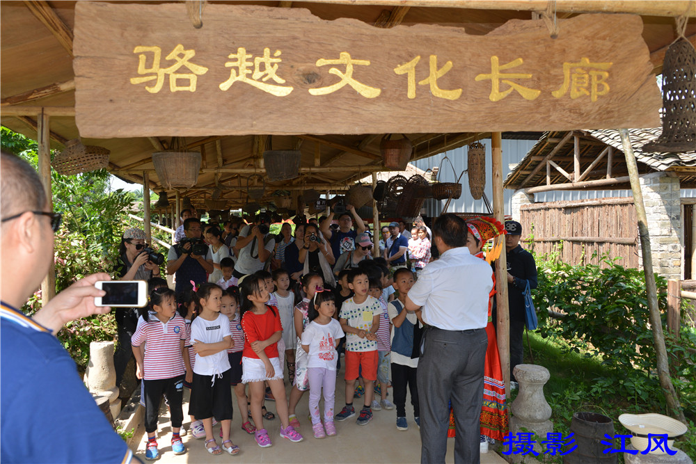 广西骆越文化研究会会长谢寿球给游客介绍广西骆越文化 摄影 江风