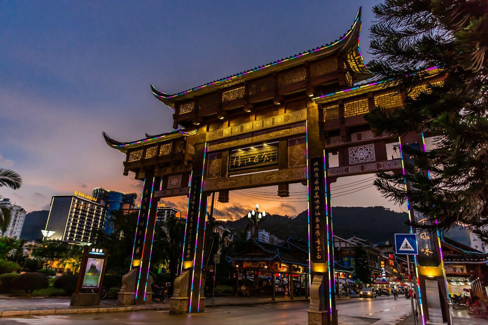 "漳江夜食"的牌楼后就是小吃夜市一条街,紧挨着邓恩铭广场 荔波县