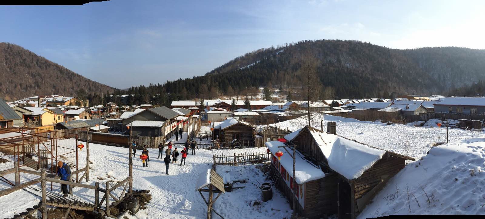 从山坡山俯瞰村庄,总结东北乡村的几个要素:蓝天,白雪,红灯笼,炊烟